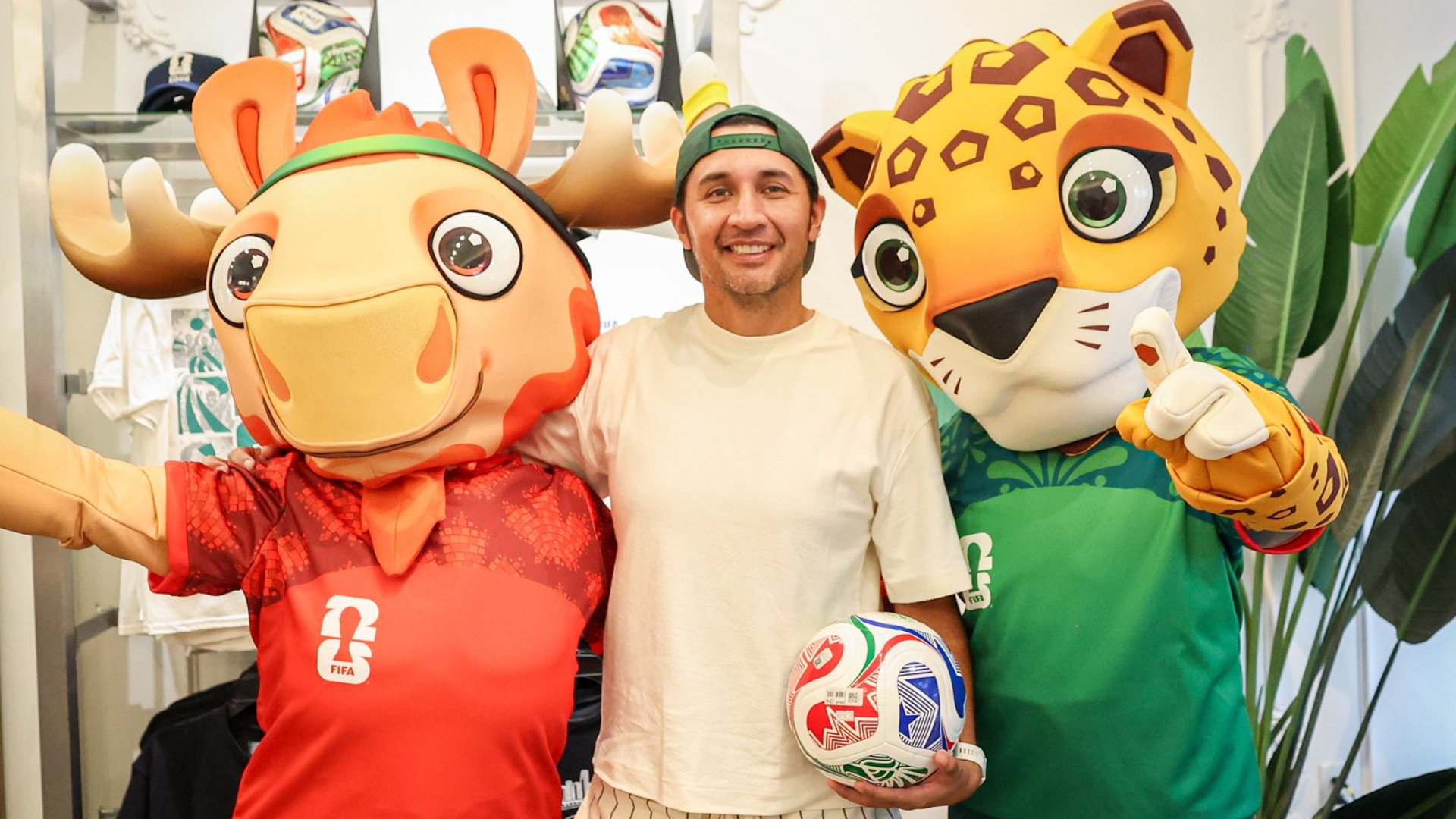 Aficionado posando junto a dos de las mascotas de la Copa del Mundo
